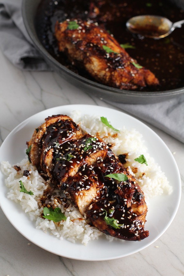 Sesame Sweet Chili Chicken cooked and sliced on a plate with rice and cilantro.  It is slightly sweet, tangy, savory, nutty, with a touch of heat. You can prepare it days ahead, it takes just minutes to prepare, minutes to cook, and everyone will love it!! #chicken #marinades #easydinner #easychicken #chickenrecipes #easysauces #healthydinner #healthyfood #healthyrecipes