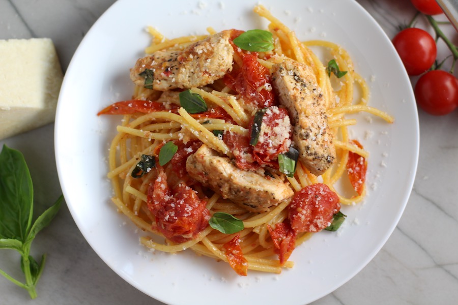 Chicken and Cherry Tomato Pasta with basil and parmesan on a plate. It's easy and so delicious! #pasta #tomatoes #easydinner #dinner #easyrecipes #healthydinner #chicken