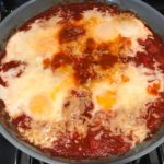 Skillet Eggs in Spicy Tomato Pepper Sauce with Manchego Cheese cooked in a skillet. With a smoky, spicy, thick, and luscious red pepper tomato sauce. #eggs #huevosrancheros #tomatosauce #easydinner #brunch #shakshuka