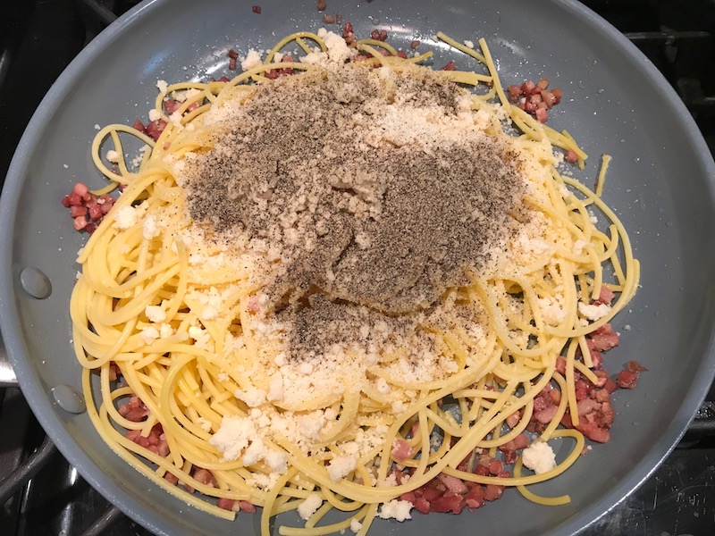 Pasta with Parmesan cheese and ground pepper on top in skillet for Pancetta, Parmesan, and Pepper Pasta. The Pancetta gives a salty and slightly peppery flavor, Parmesan cheese creates a nutty and creamy sauce, and the ground black pepper gives a peppery flavor that makes this pasta stand out. #pasta #easypasta #easydinner #dinner #italian #familydinner #onpotdinners #onepandinners #parmesan