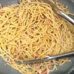 Pasta mixed with parmesan, pepper, and pancetta in skillet for Pancetta, Parmesan, and Pepper Pasta. The Pancetta gives a salty and slightly peppery flavor, Parmesan cheese creates a nutty and creamy sauce, and the ground black pepper gives a peppery flavor that makes this pasta stand out. #pasta #easypasta #easydinner #dinner #italian #familydinner #onpotdinners #onepandinners #parmesan