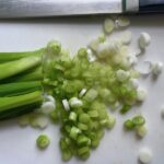 Sliced scallions for Chilled Golden Corn Soup with Turmeric. Scallions on top for garnish. It's thick, creamy, silky and delicious.  The entire family will love this easy stovetop corn soup! #summerfood #cornsoup #corn #vegetarian #vegetablerecipes #sides