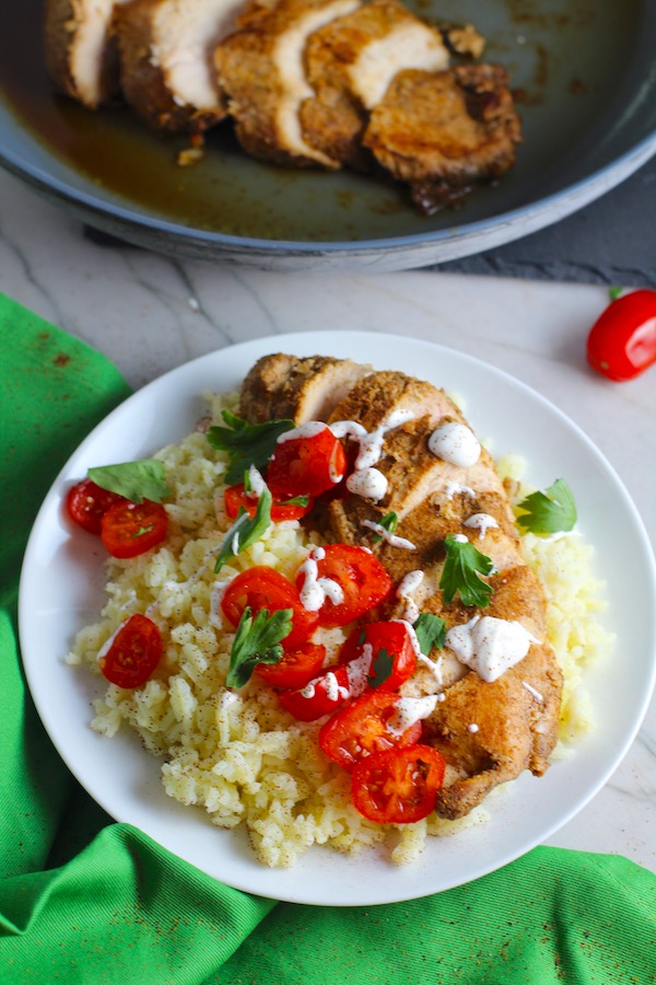 Sliced Mexican Chicken on rice with tomatoes, sour cream, & cilantro. This marinade is an easy, make-ahead, and delicious recipe! The chicken is infused with so much smokey, savory flavors from the fresh garlic, chili powder, and cumin.  #marinade #chicken #easydinners