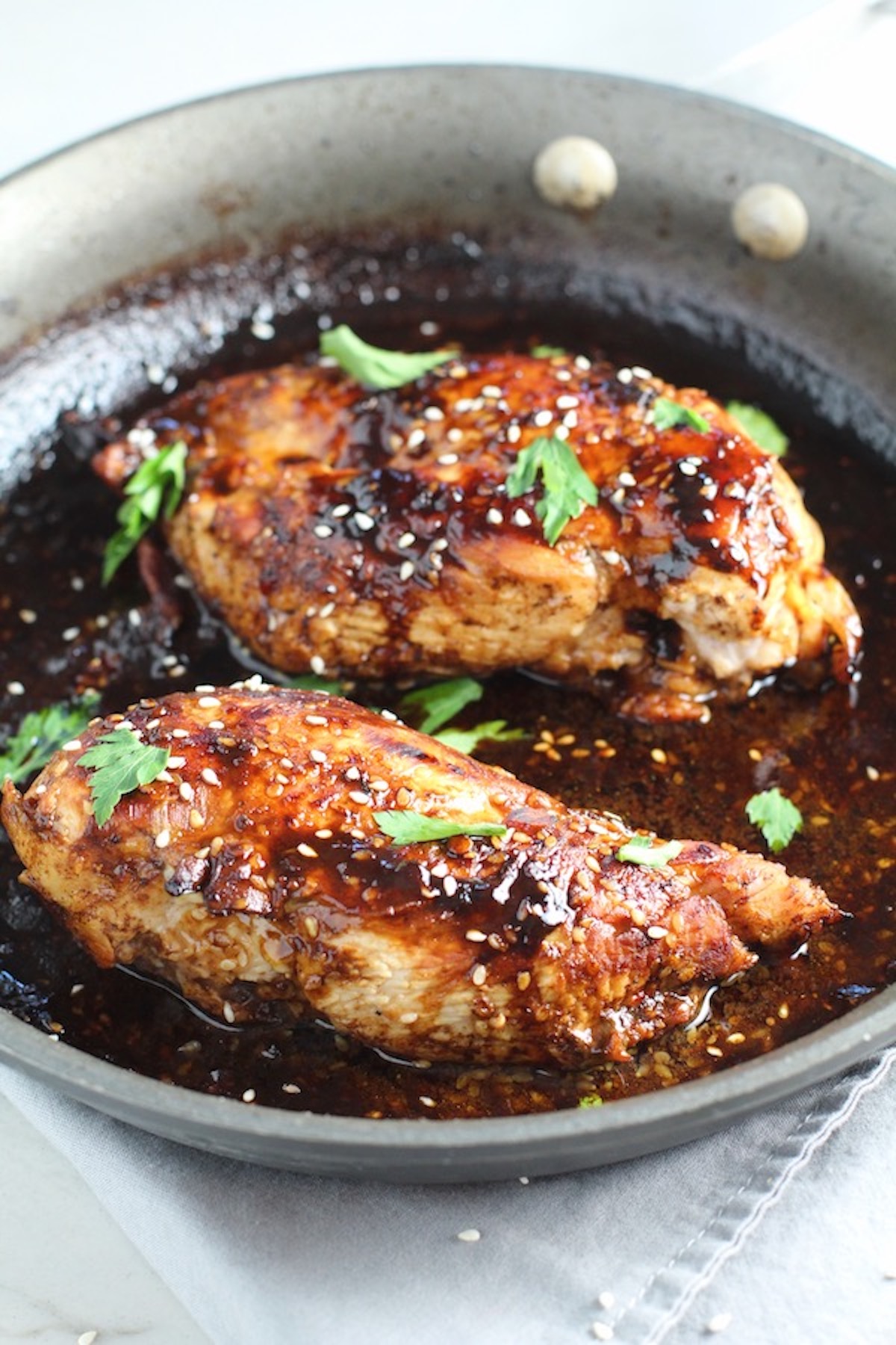 Sesame Sweet Chili Chicken cooked in skillet with cilantro leaves.  This is one of the Easy Chicken Marinades that are great for Summer grilling, freezing for the winter, or just frying up for dinner!