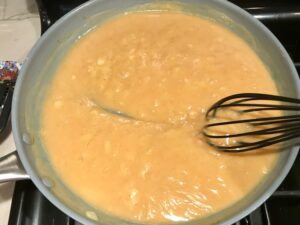 Curry Sauce in pan for Family Coconut Curry. The sauce has onion, coconut milk, ginger, garlic, and warm Indian Curry spices.