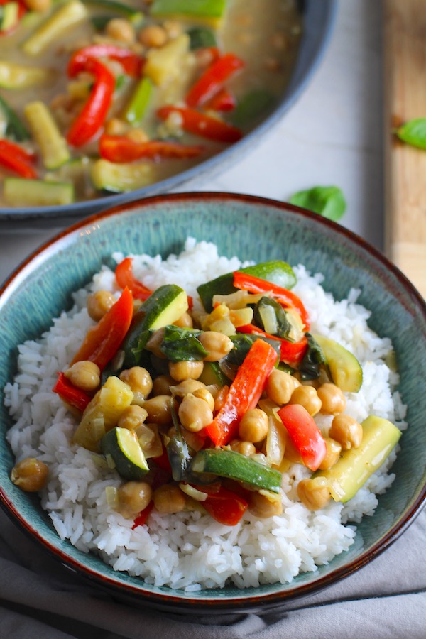 Family Chickpea Coconut Curry over rice in a bowl with red bell pepper, zucchini, onion, coconut milk, and warm Indian Curry spices.