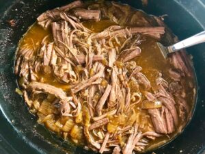 Smoky Pulled Beef Brisket in the Slow Cooker is smokey, savory, tender, moist, and full of flavor. In a delicious sauce, it goes great on a sandwich, over polenta, on rice, or potatoes. #slowcooker #crockpot #brisket #beefbrisket #pulledbeef #pulledpork