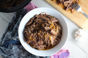 Pulled Beef Brisket in a bowl and in the Slow Cooker is smokey, savory, tender, moist, and full of flavor. In a delicious sauce, it goes great on a sandwich, over polenta, on rice, or potatoes. #slowcooker #crockpot #brisket #beefbrisket #pulledbeef #pulledpork