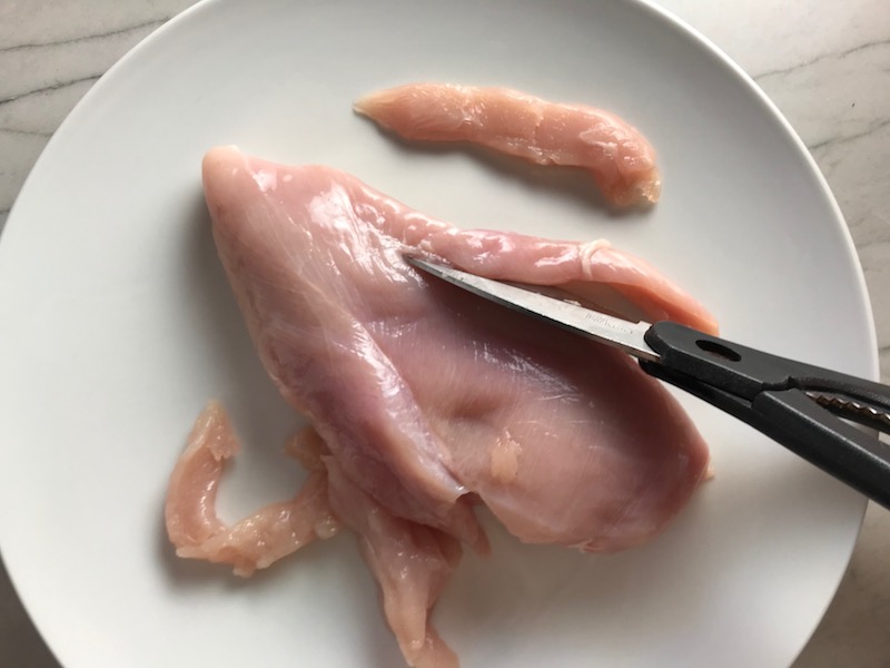 Cutting raw chicken for Chicken Mushroom Stroganoff with spinach.   It has a thick, creamy, savory mushroom sauce with a touch of tangy sour cream. #chickendinners #chickenrecipes #familydinners #dinnerideas