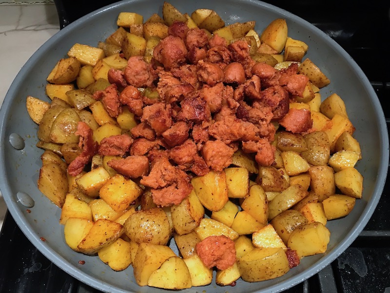 Chorizo and potatoes in skillet for Patatas Bravas with chorizo and creamy Paprika aioli. This Patatas Bravas Recipe, or Spicy Potatoes, is easy, indulgent, and utterly delicious!  #potatorecipes #potatoes #potatosidedishes #patatasbravas #skilletpotatoes #sidedishes #chorizo
