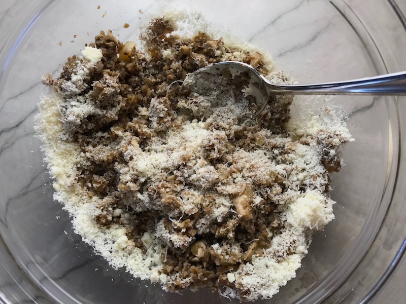 Mixing mushrooms and parmesan in bowl for Mini Beef Wellington Bites. They are flaky and buttery Puff Pastry is filled with a creamy mushroom and parmesan filling and tender beef filet.  #appetizers #partyfood