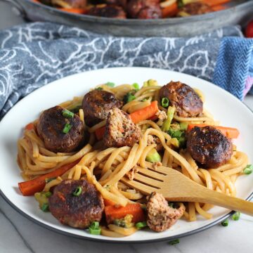 Teriyaki Meatball Stir Fry with carrots and noodles on a plate with a bamboo fork.