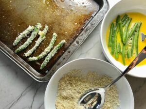 Making Parmesan Green Bean Fries and putting on sheet pan.  Such a great way to transform beans and add a new vegetable into dinner rotation. #vegetablerecipes