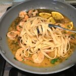 Pasta added to Shrimp and orange sauce in skillet for the Orange Brown Butter Shrimp Pasta Recipe. #shrimprecipes #shrimppasta #easydinners #dinnerideas 