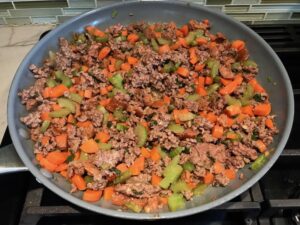 Beef filling in pan for Cottage Pie recipe.  It has Spanish Chorizo and ground beef cooked in a rich and savory gravy with veggies and herbs.  Creamy mashed potatoes sit on top with manchego, parmesan, and garlic. #dinnerideas #cottagepie #shepherdspie