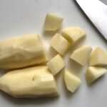 Cutting raw potatoes for Cottage Pie recipe. It has Spanish Chorizo and ground beef cooked in a rich and savory gravy with veggies and herbs.  Creamy mashed potatoes sit on top with manchego, parmesan, and garlic. #dinnerideas #cottagepie #shepherdspie