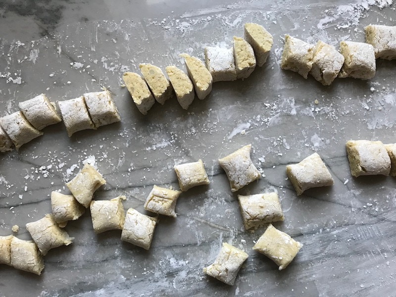 Cauliflower Gnocchi cut on marble.  They are soft, silky, buttery, and melt-in-your-mouth!  Made with cauliflower, they're a healthier version to traditional gnocchi! Add my simple Garlic Butter Sauce or Tomato Sauce and they are heaven.  #dinnerideas #gnocchi #cauliflower