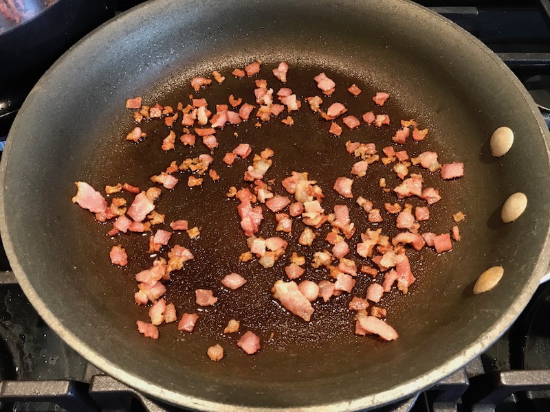 Cooked bacon pieces in pan for Bacon Mac and Cheese. It has a creamy and cheesy sauce with a touch of smokiness from the bacon, coats each piece of pasta.  On top, crispy crunchy, indulgent bacon fat cracker crumbs!