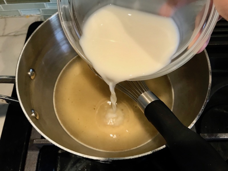 Adding cornstarch slurry to broth for Bacon Mac and Cheese. It has a creamy and cheesy sauce with a touch of smokiness from the bacon, coats each piece of pasta.  On top, crispy crunchy, indulgent bacon fat cracker crumbs!