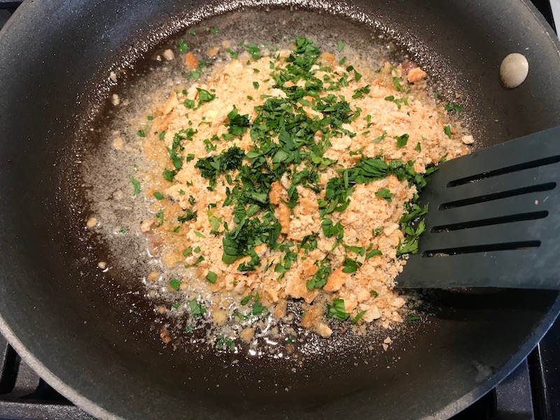 Cracker crumbs and parsley in pan for Bacon Mac and Cheese. It has a creamy and cheesy sauce with a touch of smokiness from the bacon, coats each piece of pasta.  On top, crispy crunchy, indulgent bacon fat cracker crumbs!