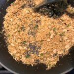 Cracker crumbs and parsley in pan for Bacon Mac and Cheese. It has a creamy and cheesy sauce with a touch of smokiness from the bacon, coats each piece of pasta.  On top, crispy crunchy, indulgent bacon fat cracker crumbs!