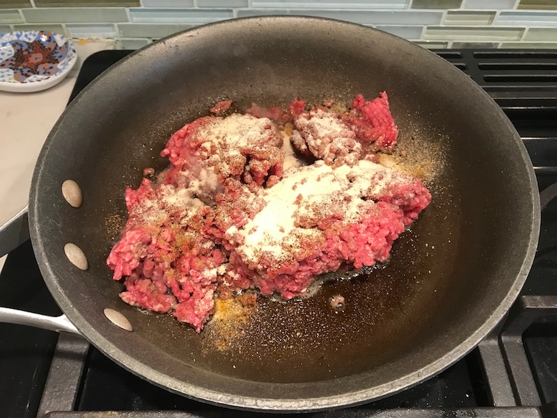 Ground Beef in pan with seasonings for Ground Beef Empanadas. Flaky, buttery pastry on the outside with a savory, smokey, salty ground beef filling.
