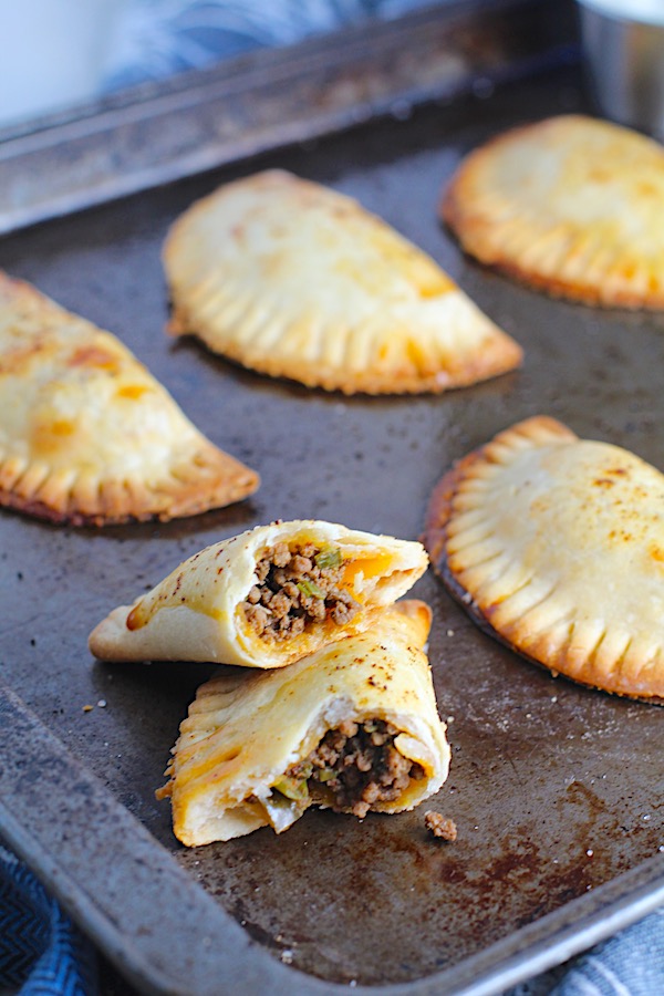 Ground Beef Empanadas on a pan.  Flaky, buttery pastry on the outside with a savory, smokey, salty ground beef filling.