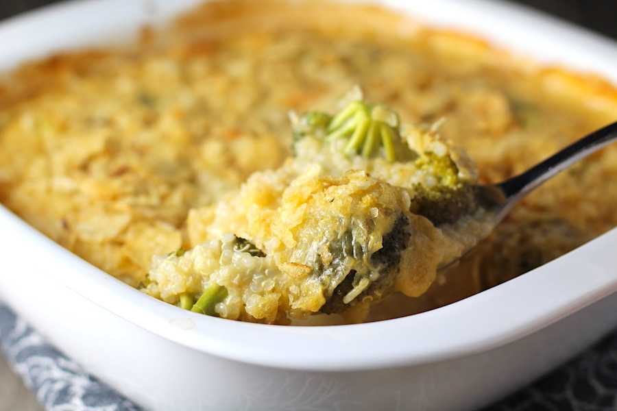 Spoon scooping Broccoli Cheese Quinoa Bake with potato chips on top. It's a comfy cozy casserole that's perfect to make ahead for a simple weeknight side or main dish.