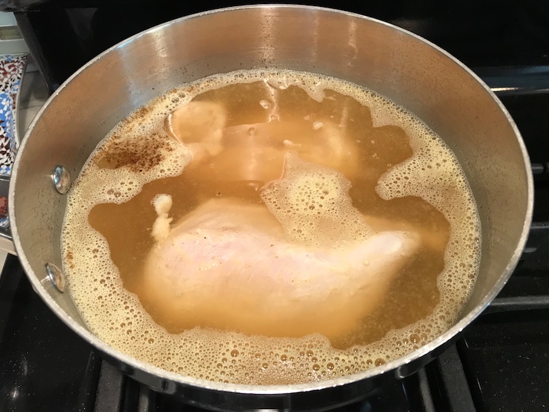 Chicken boiling for Creamy Chicken Enchilada Soup.  It's creamy, hearty, slightly spicy with green chiles and smokey seasonings that bring so much depth.  Corn tortilla strips act like the noodles in this soup!