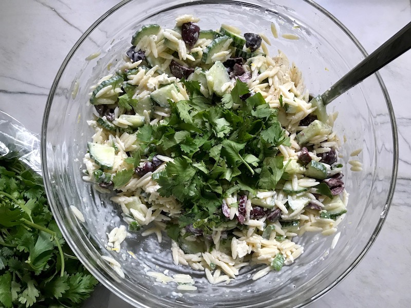 Cilantro added to Greek Orzo Salad with Kalamata Olives, Cucumbers, and Feta Cheese.  It's mixed with a creamy lemon dressing that's bright and light!