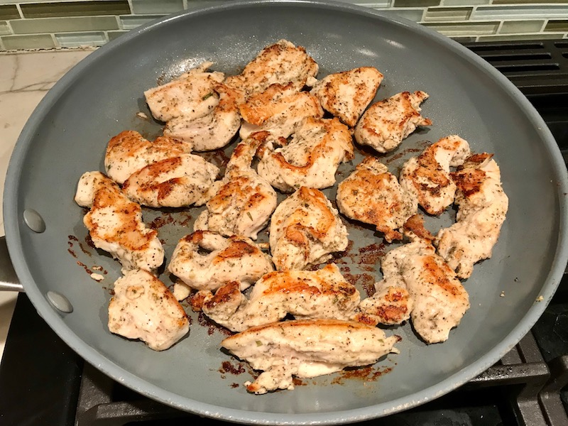 Chicken cooking in pan for Tarragon Mustard Chicken with Red Peppers. It's creamy, tangy, savory, and so addictive.