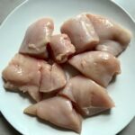 Cut raw chicken on a plate for a BBQ Chicken Pizza Recipe
