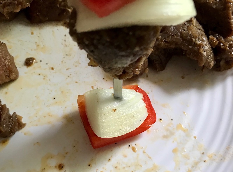 Putting skewer through onion and red pepper for Garlic Steak Kabobs. #beefkabobs #steakkabobs