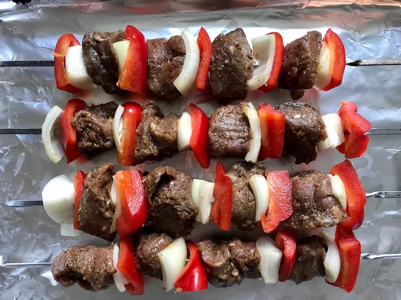 Raw Garlic Steak Kabobs with red pepper and onion on a pan. #beefkabobs #steakkabobs