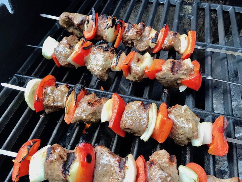 Garlic Steak Kabobs with red pepper and onion on a grill. #beefkabobs #steakkabobs