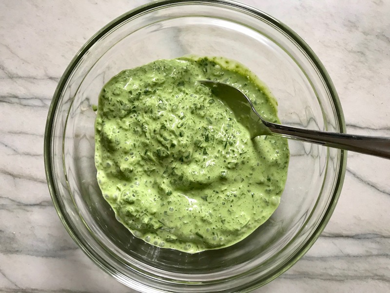 Basil, chives, spinach, and sour cream blended in a bowl for Green Rice Recipe. It takes white rice from plain to amazing with just 5 ingredients. Filled with herbs and spinach, it has the perfect herby flavor.