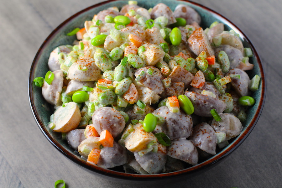 Red Potato Salad Recipe with Edamame and Harissa in a bowl on table. It's creamy, crunchy, meaty, tangy, peppery, salty, and oh, it's UNBELIEVABLE!