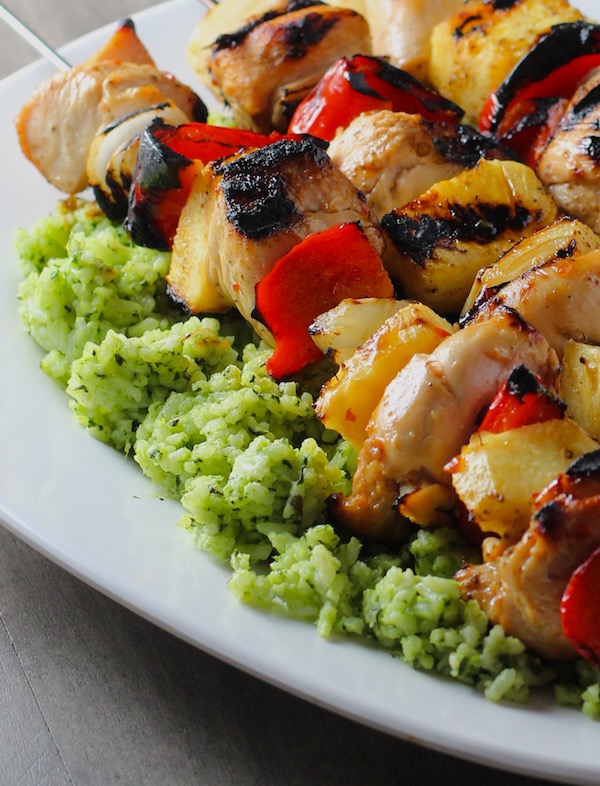 Green Rice on platter with chicken kabobs on top.  This Recipe takes white rice from plain to amazing with just 5 ingredients.  Filled with herbs and spinach, it has the perfect herby flavor.