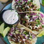 Korean Bulgogi Sauce Beef Tacos on a plate with flavorful Korean beef, crunchy Sesame Cabbage Slaw and a creamy, cool, Cilantro Lime Sriracha sauce!