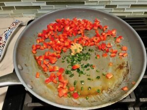Diced red pepper, jalapeno, and garlic in pan for Creamy Corn and Blackened Chicken skillet dinner
