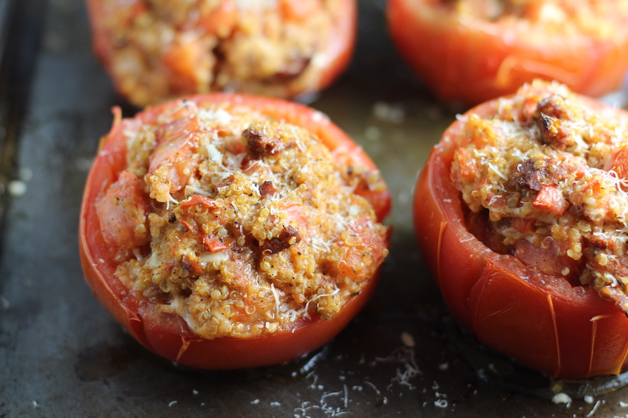 Stuffed Tomatoes on sheet pan on counter with chorizo, quinoa, parmesan cheese, chives, garlic, and oregano are simply divine! 