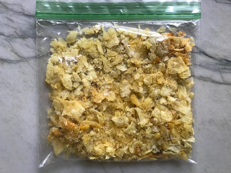Crushed potato chips in storage bag for Broccoli Cheese Quinoa Bake It's a comfy cozy casserole that's perfect to make ahead for a simple weeknight side or main dish.