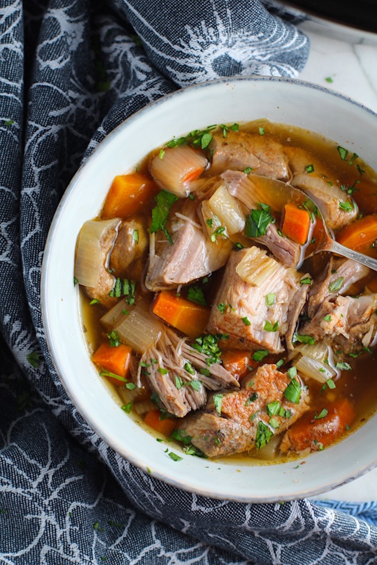 Paprika Pork Stew Recipe in a bowl with carrots, onion, parsley. It's an easy family dinner. 