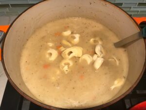 Tortellini added to soup in pot for Creamy Chicken Sausage and Tortellini Soup. It's silky and creamy with onions, garlic, Chicken sausage, and zucchini bring so much flavor and texture.  The tortellini give that delicious salty, creamy, hearty bite! 