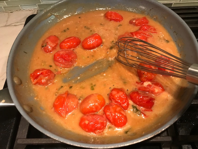 Bacon Tomato Sauce in pan for Smothered Chicken with Bacon, and Tomatoes.  The chicken is smothered in a thickened sauce infused with smokey and salty bacon flavor.  Cherry tomatoes give a sweet and tangy pop.