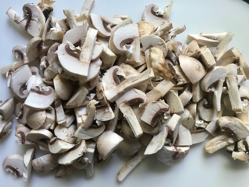 Sliced mushrooms for Chorizo Sausage and Green Bean Casserole in a serving bowl are a creamy and savory side dish.