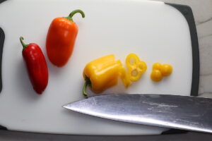 Knife slicing mini sweet peppers for Garlic Potato and Steak Bites Recipe.  It's an easy and delicious, one-pan family dinner!  You get fantastic salty, buttery, tender steak and potatoes in each and every mouthwatering bite! 