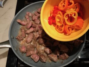 Adding sliced sweet peppers to steak bites for Garlic Potato and Steak Bites Recipe. It's an easy and delicious, one-pan family dinner!  You get fantastic salty, buttery, tender steak and potatoes in each and every mouthwatering bite! 