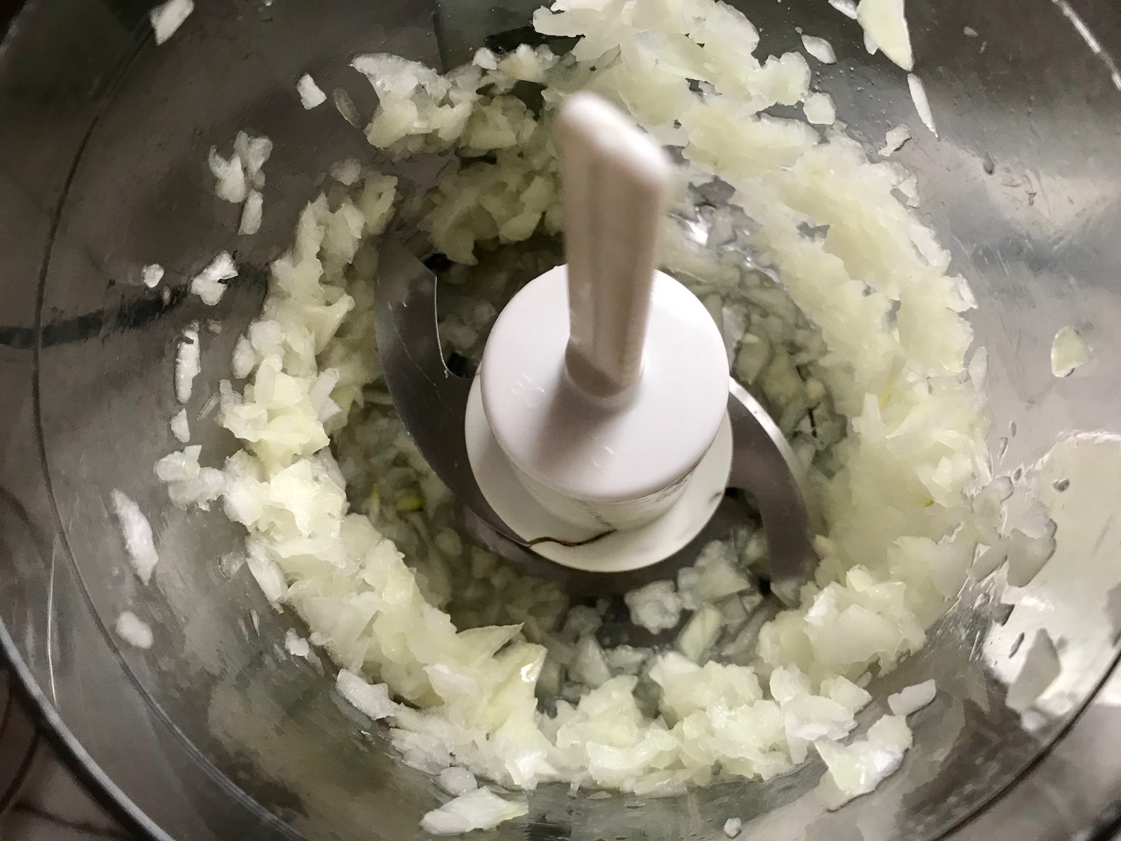 Minced onion in food processor for Healthy Meatballs with Zucchini & Lean Beef. They're loaded with flavor from the garlic, minced onion, salt, and pepper. The zucchini brings moisture, texture, and bulks up the meatballs with healthiness.