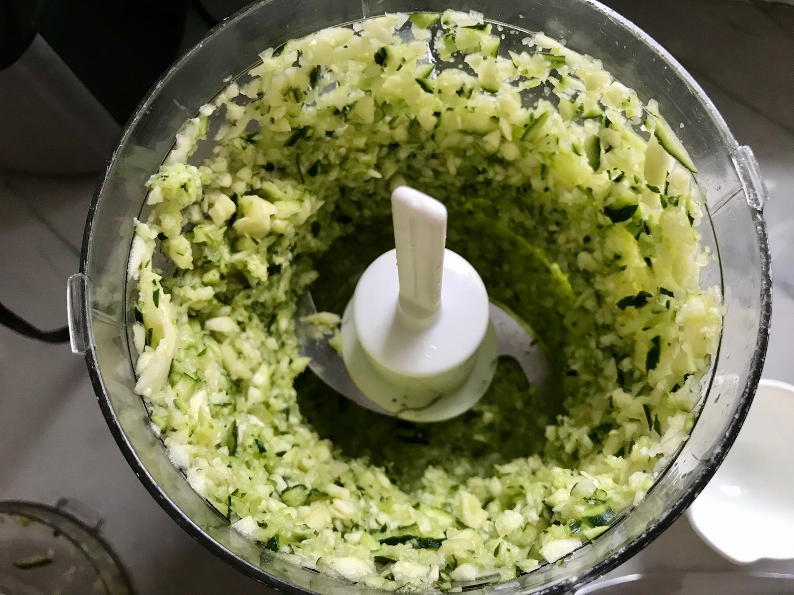 Minced zucchini in food processor for Healthy Meatballs with Zucchini & Lean Beef. They're loaded with flavor from the garlic, minced onion, salt, and pepper. The zucchini brings moisture, texture, and bulks up the meatballs with healthiness.